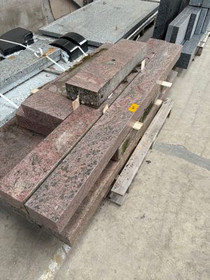 a pile of red granite blocks on the ground