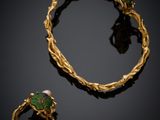 a close up of a gold bracelet and ring with a green stone