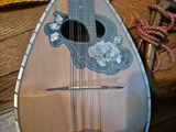 a mandolin sitting on a wooden floor next to a wooden chair