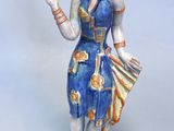 une figurine représentant une femme tenant un éventail et un éventail