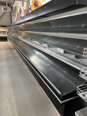 many empty shelves in a store with no people inside