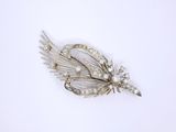 a close up of a silver brooch with a flower on it