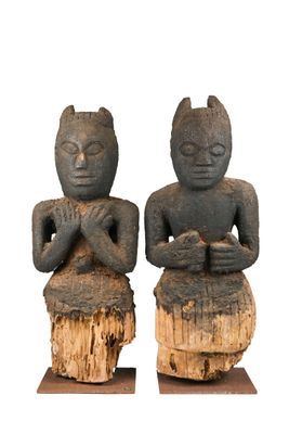 deux statues représentant un homme et une femme assis sur une souche d'arbre