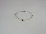 a close up of a silver bracelet with a brown stone