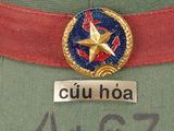 a green hat with a red band and a gold star on it