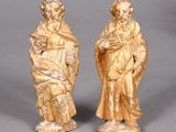pair of carved figurines of a man and a woman holding a child