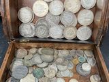 une boîte en bois remplie de pièces, posée par terre