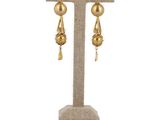 a close up of a pair of earrings on a stand