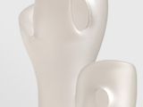 a white sculpture of a man and a woman on a table