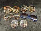 Plusieurs paires de lunettes sont alignées sur une surface noire