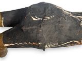 a wooden statue of a person laying down on the ground