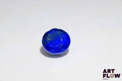 un gros plan d'une pierre bleue posée sur une surface blanche