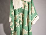 an image of a green and white coat hanging on a hanger