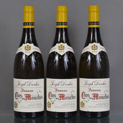 three bottles of wine are lined up on a table