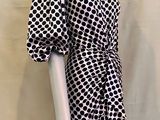 Le mannequin porte une robe noire et blanche à carreaux noirs et blancs.