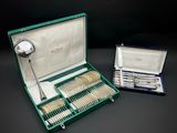 un coffret vert contenant de l'argenterie sur une table