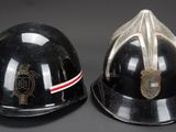 pair of black fire helmets with red and white stripes on them