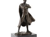 statue of a man in a cloak and cape standing on a marble base