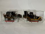 deux modèles réduits de voitures anciens dans une vitrine transparente