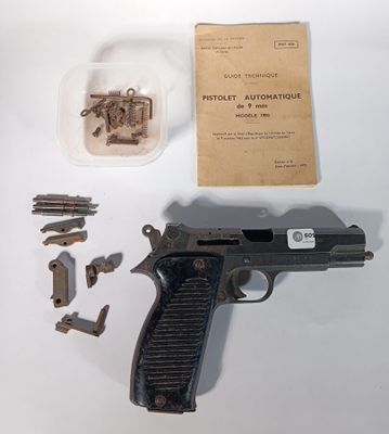 un pistolet et quelques vis posés sur une table