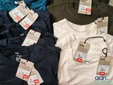 a lot of t - shirts with tags on them sitting on a table