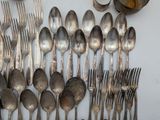 a lot of silver spoons and forks on the table