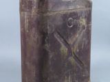 an old purple metal canister sitting on top of a white surface
