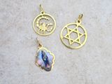 two gold pendants with religious symbols on them sitting on a table