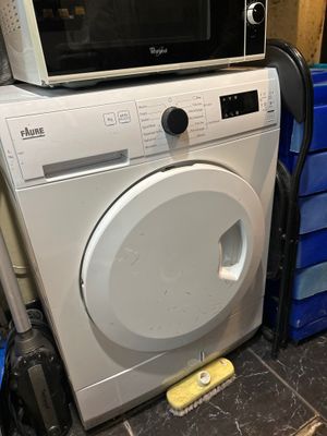 une machine à laver et un micro-ondes dans une pièce
