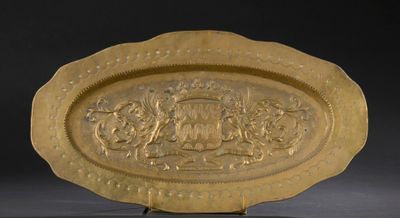 une image représentant une assiette en or sur laquelle figure un blason