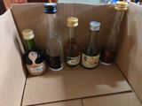 many bottles of alcohol in a cardboard box on the table