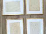 quatre dessins de nus encadrés, posés sur un plancher en bois, dans des cadres dorés