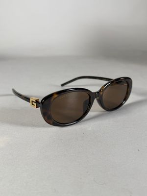 des lunettes de soleil posées sur une surface blanche, avec un fond blanc