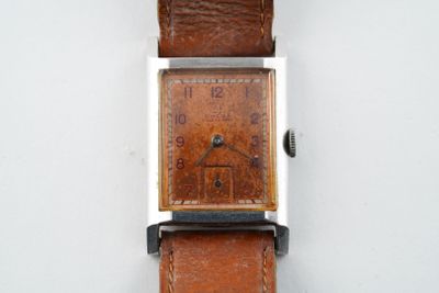 une montre posée sur une surface blanche