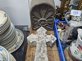 une croix posée sur une table où se trouvent de nombreuses assiettes et tasses