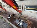 a red excavator that is on the side of a building