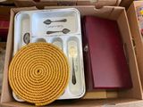 a box with a rope, fork, knife, and other items in it