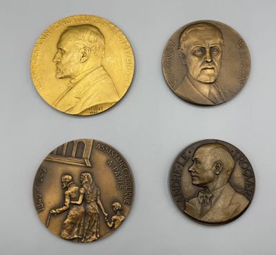 quatre médailles de bronze sur lesquelles figurent les portraits d'hommes et de femmes