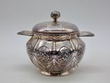 a silver pot with a lid on a white table
