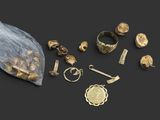 a group of gold and silver jewelry on a black surface