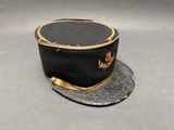 un chapeau noir orné d'une bordure dorée sur fond gris