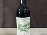 une bouteille de vin rouge posée sur une table en bois