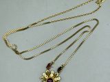 a close up of a necklace with a flower design on it
