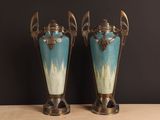 two vases sitting on a table with a black background