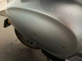 a silver motorcycle parked in a garage with a lot of scratches