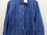 the blue shirt is hanging on a hanger on the wall