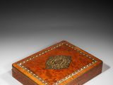 a small wooden box with a decorative design on the lid