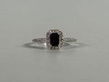 a blue sapphire and diamond ring on a white surface