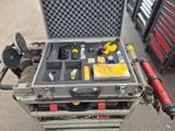 une mallette à outils contenant des outils, posée par terre