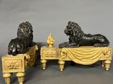 pair of antique bronze lions on a table with a drape